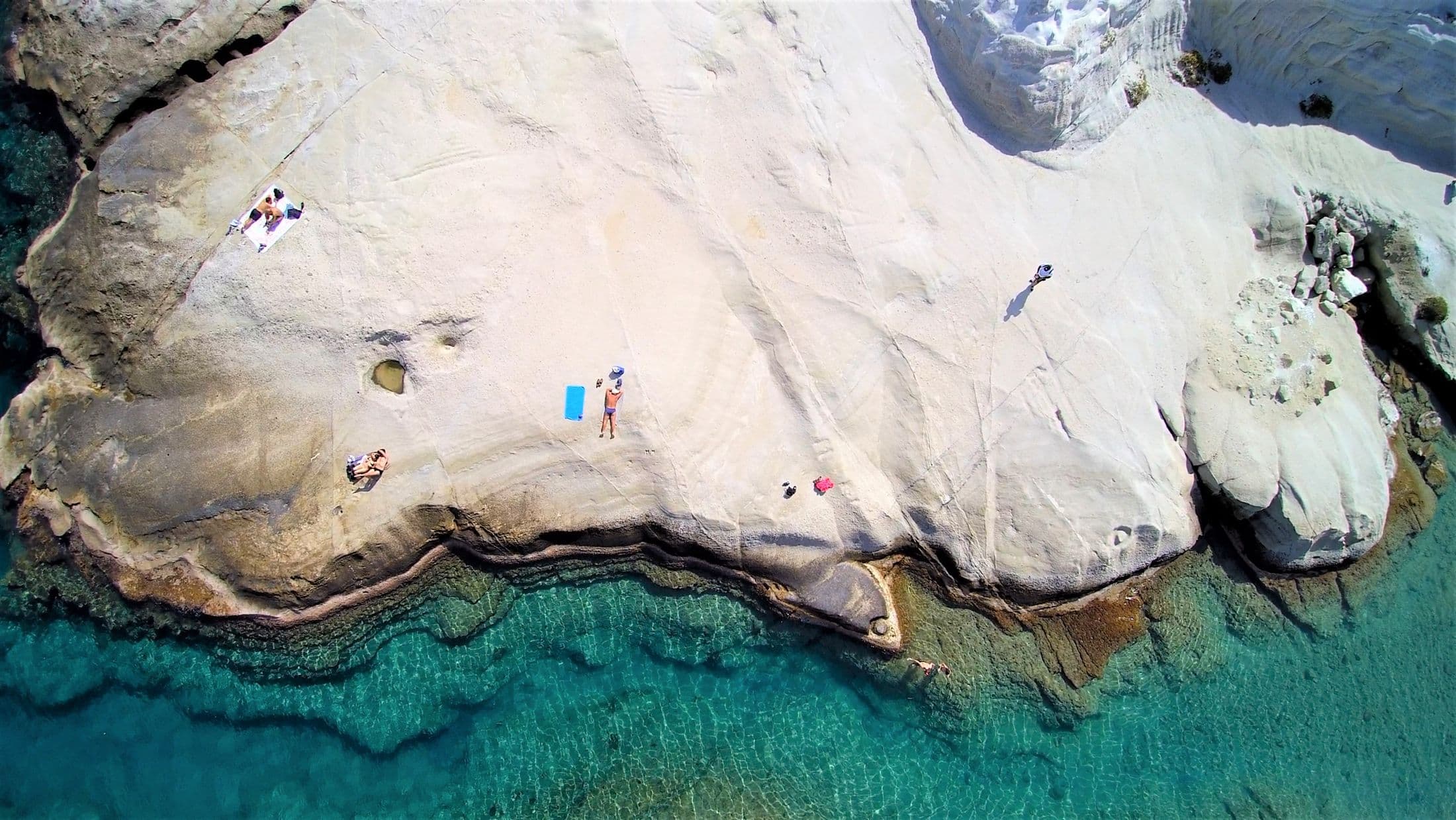 Aerial view of the white rock formations and azure water of Sarakiniko beach, Milos